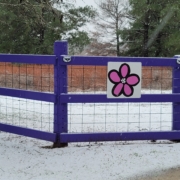 Sign on a fence with image of a five petaled pink flower